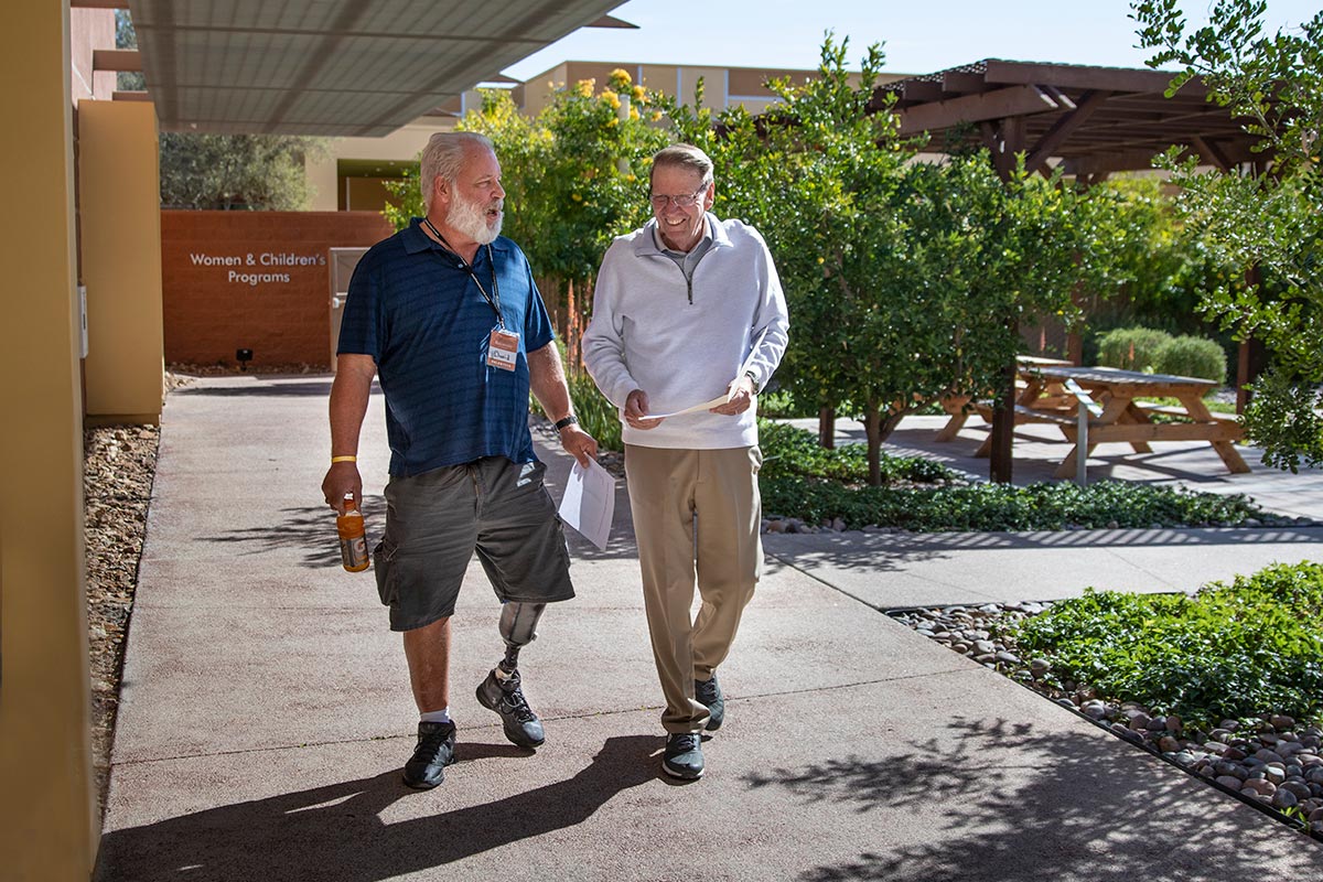 Two men walking together outside of CVRM facilities